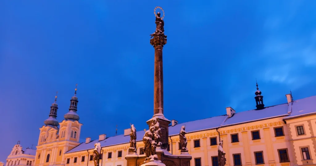 Vánoční trhy Hradec Králové – Mariánský sloup a kostel Nanebevzetí Panny Marie v Hradci Králové při zimním soumraku